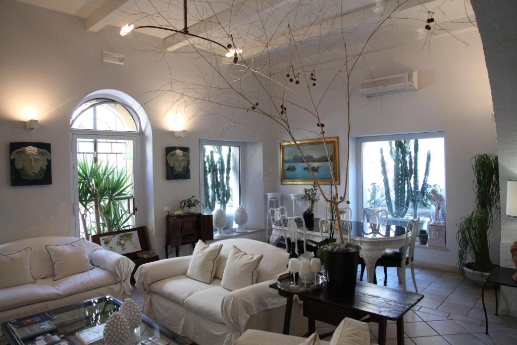 a living room with white couches and a table at B&B Casa Ruffino in Balestrate