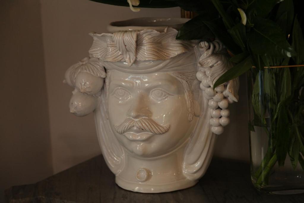 a white vase with a bust of a man at B&B Casa Ruffino in Balestrate