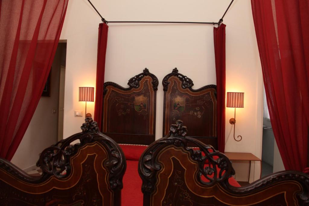 two beds in a room with red curtains at B&B Casa Ruffino in Balestrate
