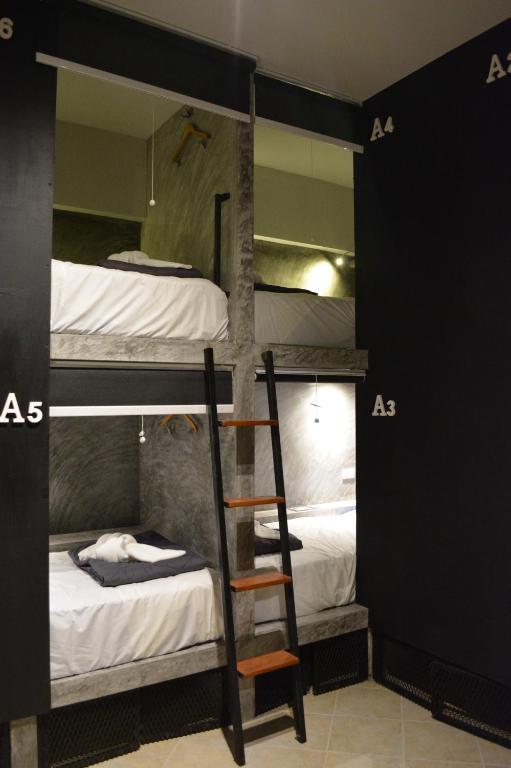 a room with three bunk beds and a ladder at Nirvana Guesthouse & Hostel in Koh Tao