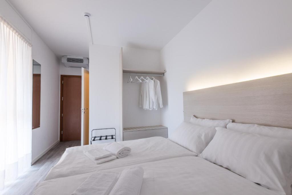 a bedroom with a white bed and white walls at Hotel Internazionale Luino in Luino