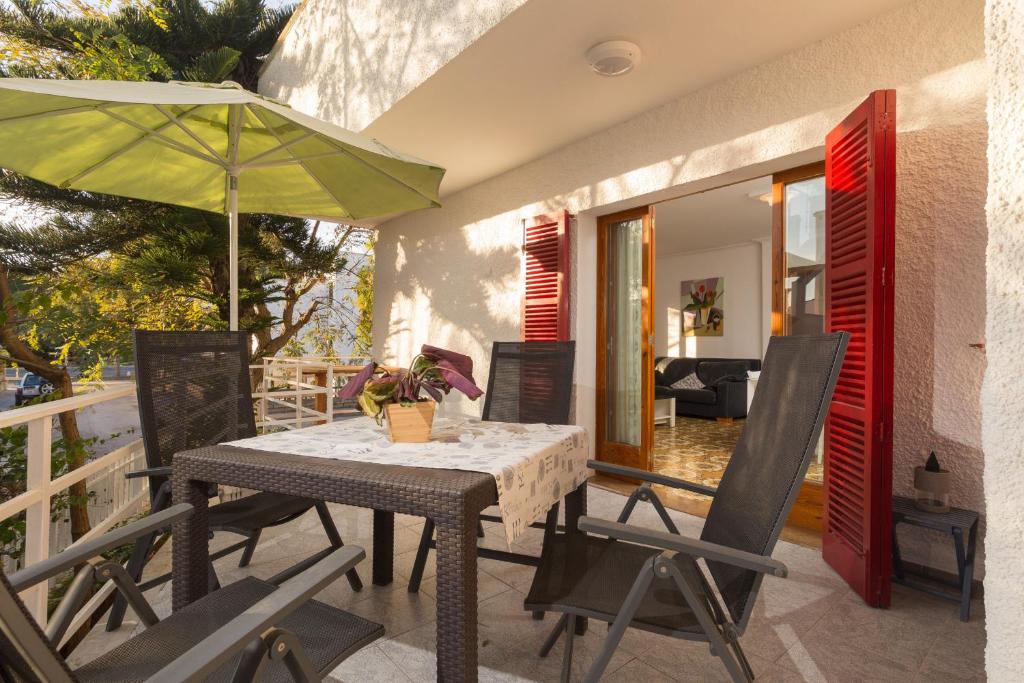 a table and chairs with an umbrella on a balcony at Villa Cactus in Port d'Alcudia