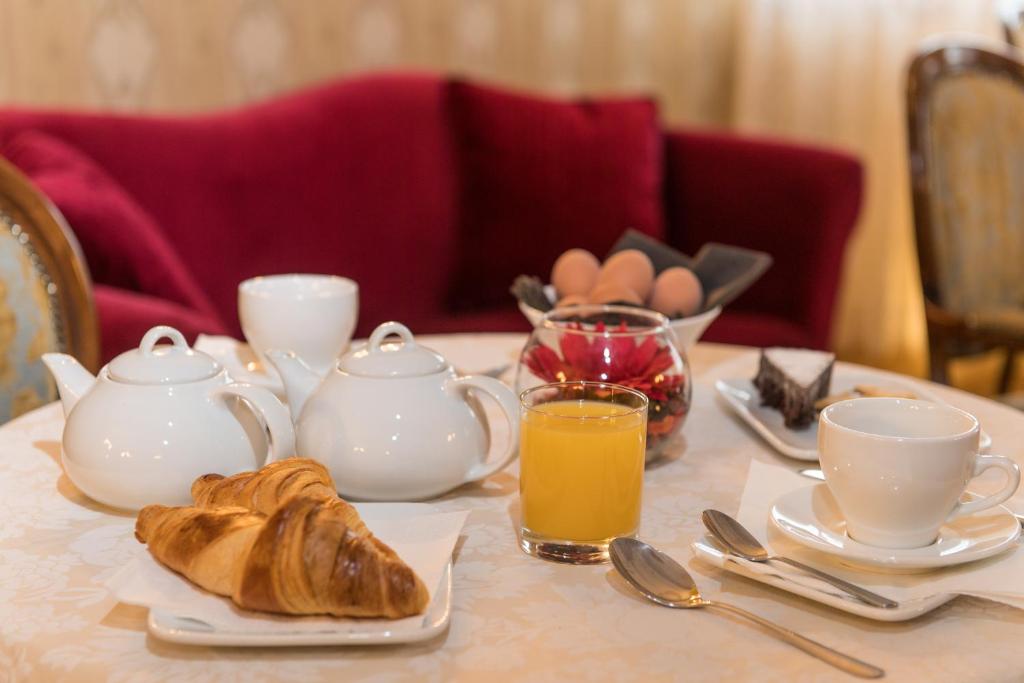 a table with a breakfast of croissants and cups and coffee at Palazzo Bembo - Exclusive Accommodation in Venice