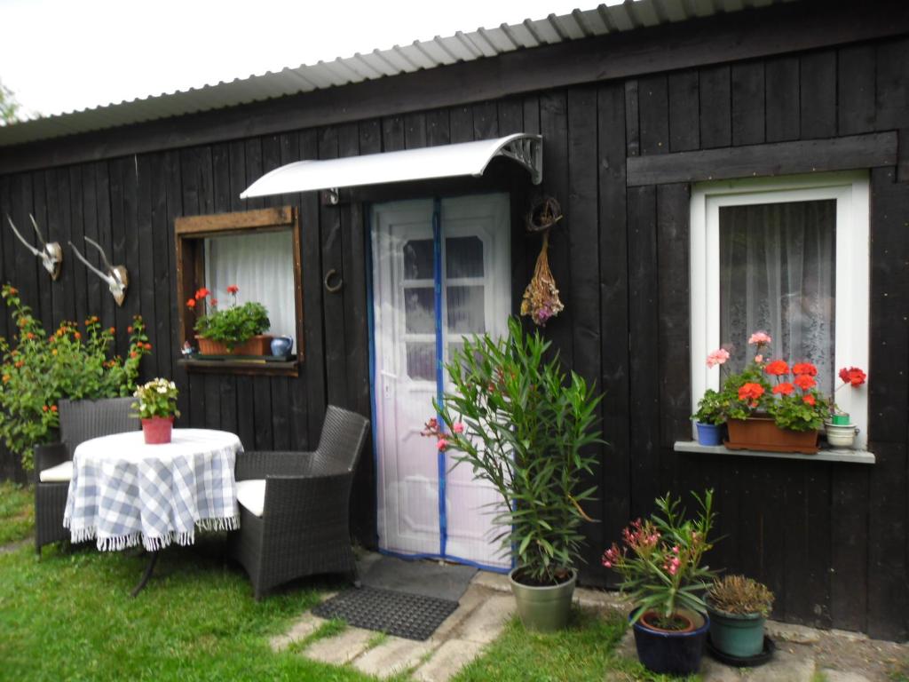 ein schwarzes Haus mit einer weißen Tür und einem Tisch in der Unterkunft Ferienwohnung Prälank in Neustrelitz