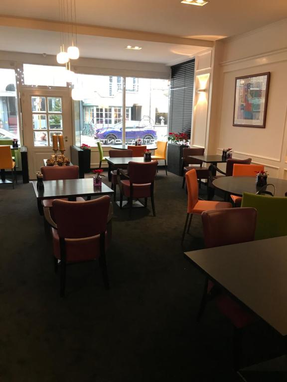 a dining room with tables and chairs in a restaurant at Hotel Honfleur in Middelkerke