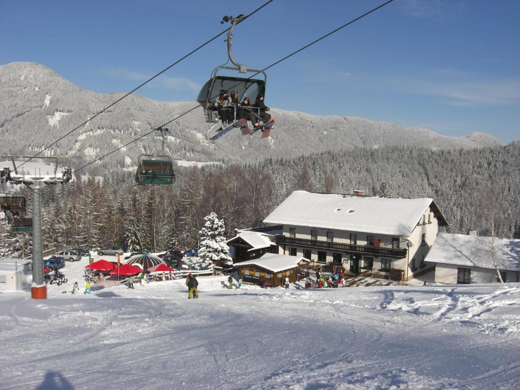 une remontée mécanique survolant une station de ski avec un lodge dans l'établissement Alpengasthof Eichtbauer, à Spital am Semmering