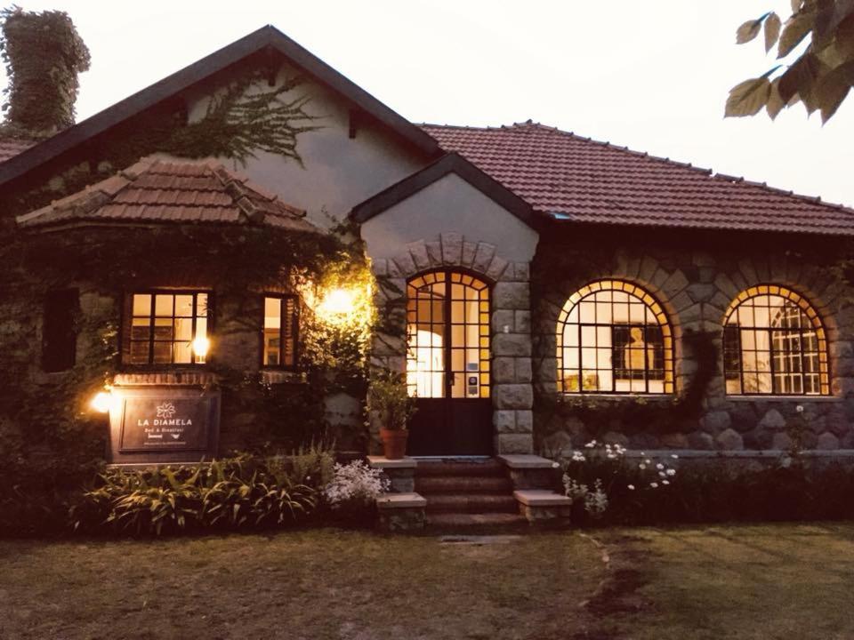 a stone house with lights in front of it at Posada La Diamela in La Cumbre