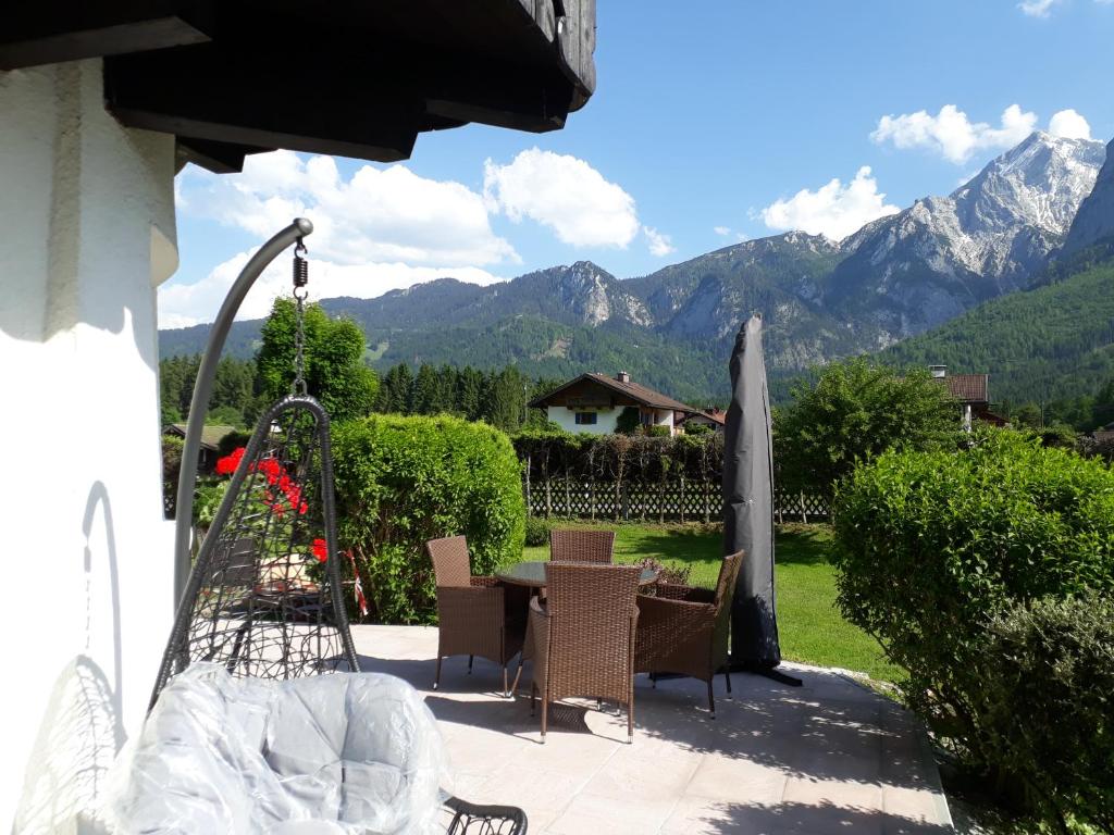 eine Terrasse mit einem Tisch, Stühlen und Bergen in der Unterkunft Haus Florian in Grainau