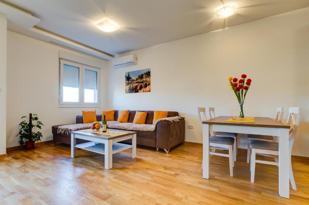 a living room with a couch and a table at Piano Apartments Delta City in Podgorica