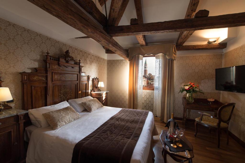 1 dormitorio con 1 cama grande y TV en Palazzo Bembo - Exclusive Accommodation, en Venecia