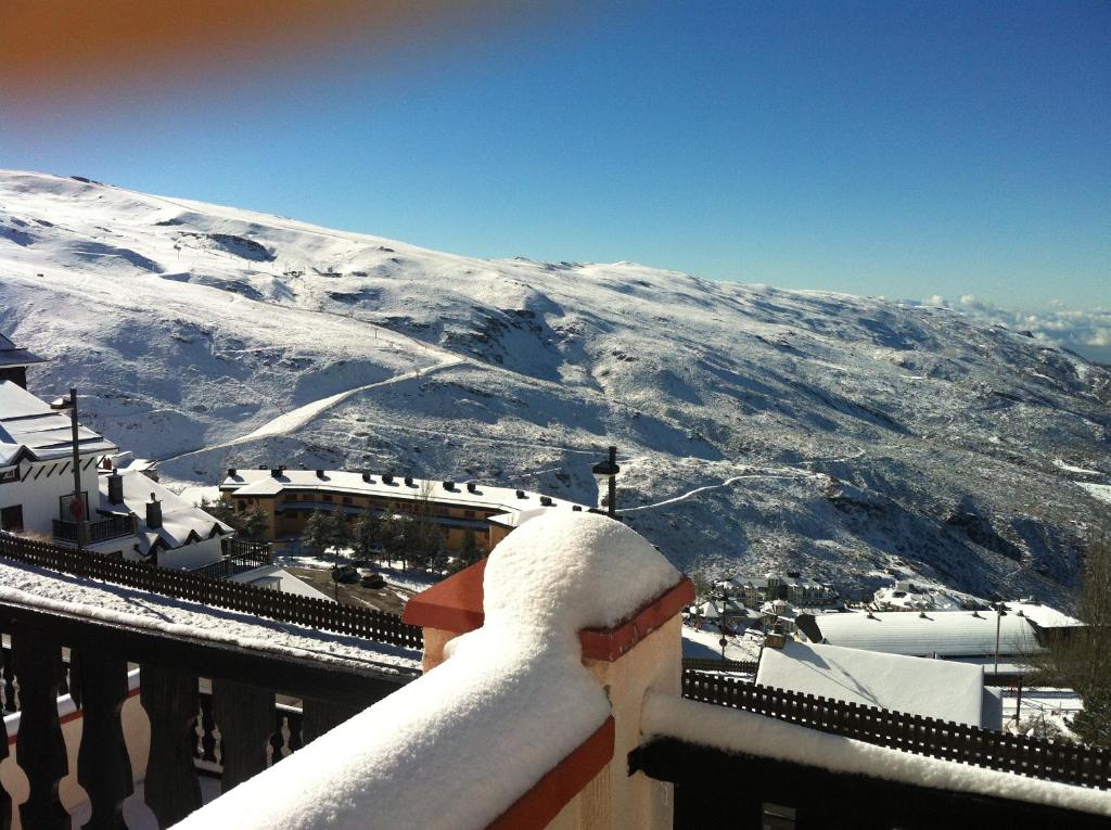 a view of a snow covered mountain from a balcony at Apartamentos Montreal in Sierra Nevada