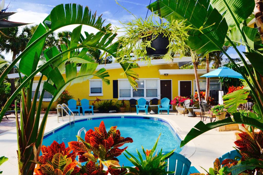 a pool in front of a house with plants at Sea Turtle Inn in Vero Beach