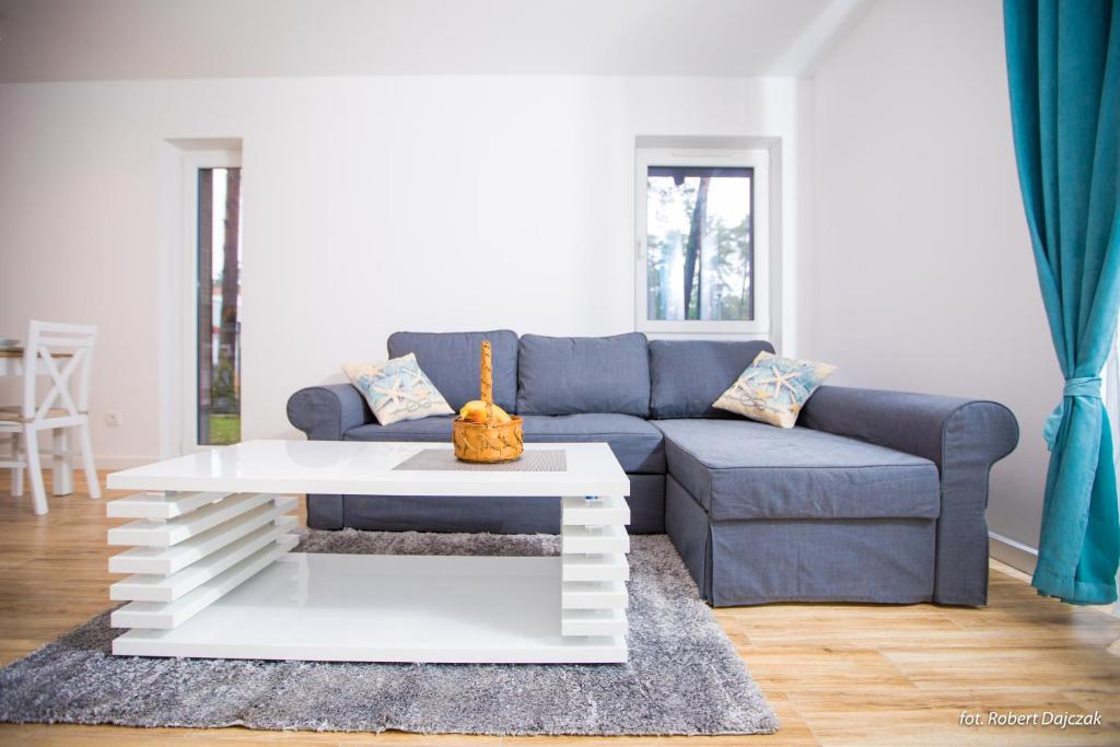 a living room with a blue couch and a white coffee table at Baltic in Pogorzelica