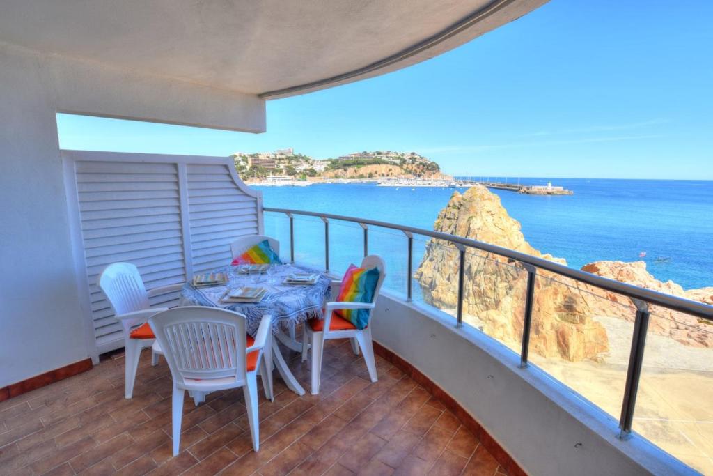 uma varanda com uma mesa e cadeiras e o oceano em C16013 Club de Mar em Sant Feliu de Guíxols
