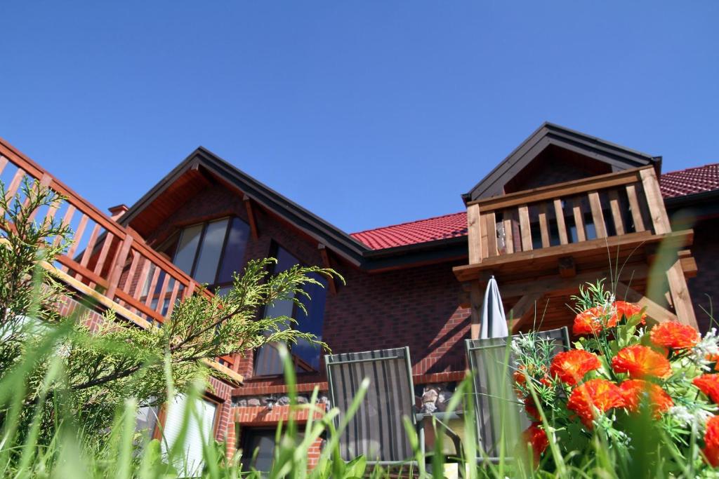 a house with a balcony and a fence with flowers at Kamminland in Stare Sady