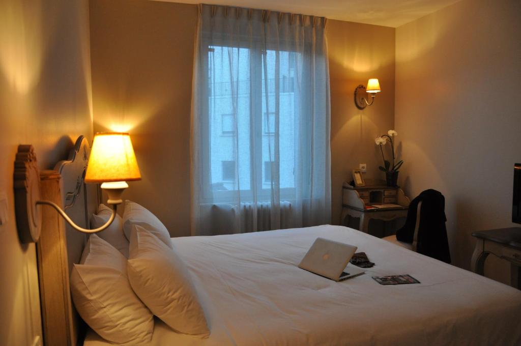 une chambre d'hôtel avec un lit et un livre dans l'établissement The Originals Boutique, Hôtel Les Poèmes de Chartres (Inter-Hotel), à Chartres