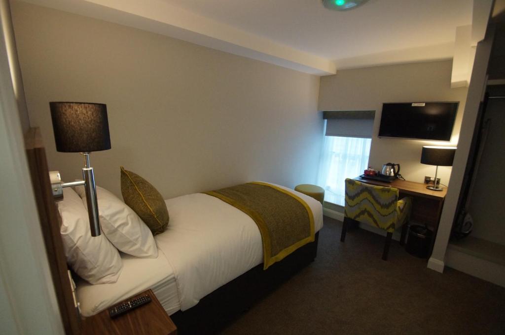 a hotel room with a bed and a desk at New Park Hotel in Carmarthen
