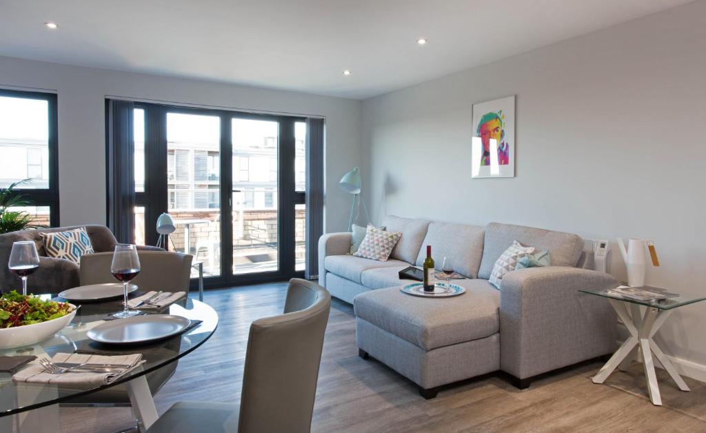 a living room with a couch and a table at Cotels at 7Zero1 Serviced Apartments - Modern Apartments, Superfast Broadband, Free Parking, Centrally Located in Milton Keynes