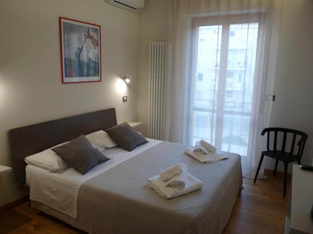 a bedroom with a large bed with towels on it at Ánemos b&b in Termoli