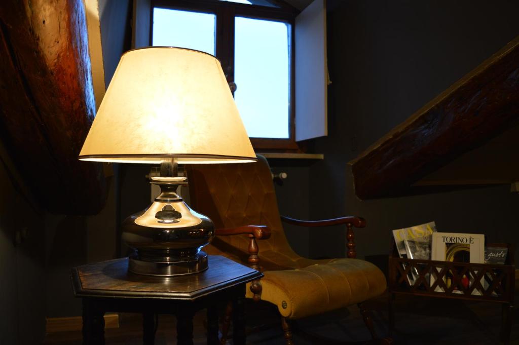 une lampe assise sur une table à côté d'une chaise dans l'établissement Viola Home, à Turin