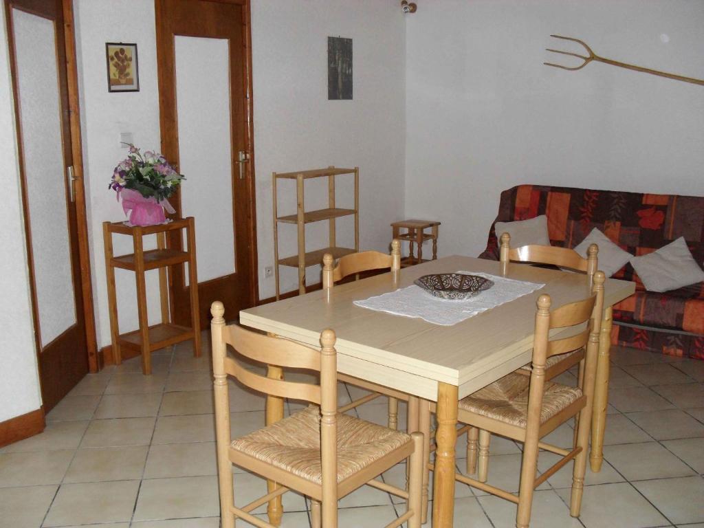 einen Esstisch und Stühle im Wohnzimmer in der Unterkunft appartement vacances à la montagne RDC in Génos