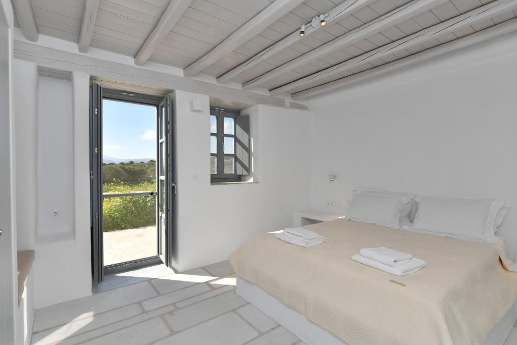 a white bedroom with a bed and a window at Sea Swell Villas at Santa Maria in Santa Maria