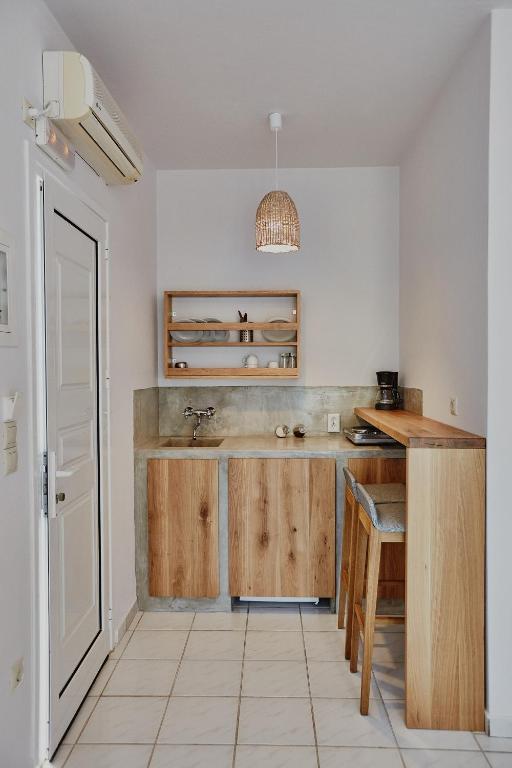 a kitchen with wooden cabinets and a sink at Irene Studios in Agios Petros