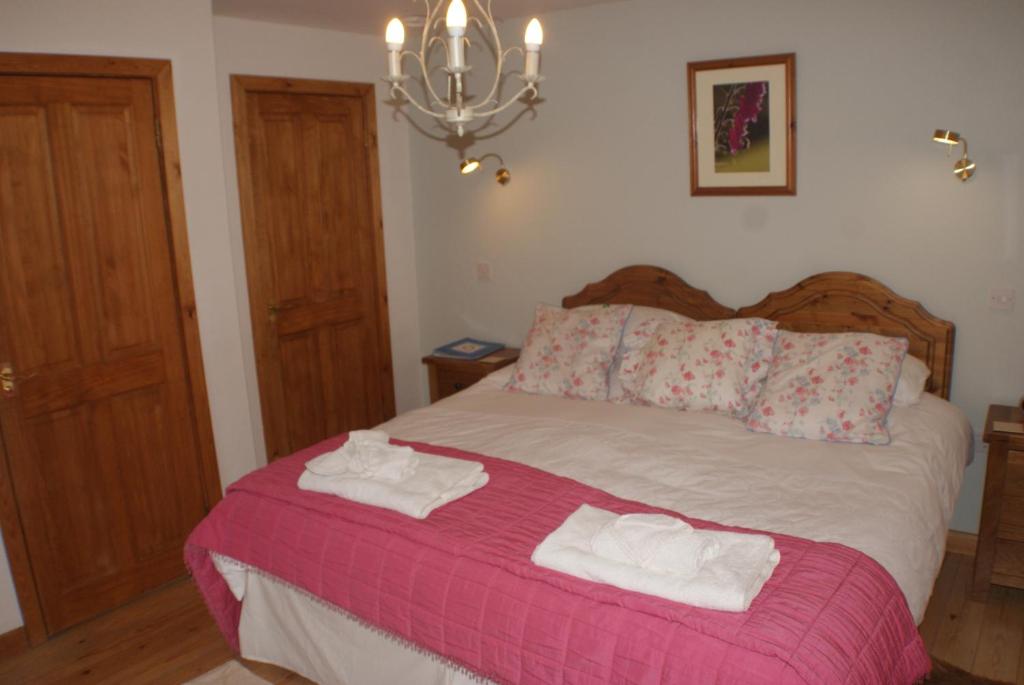 a bedroom with a bed with towels on it at Knockaloe Beg Farm in Patrick