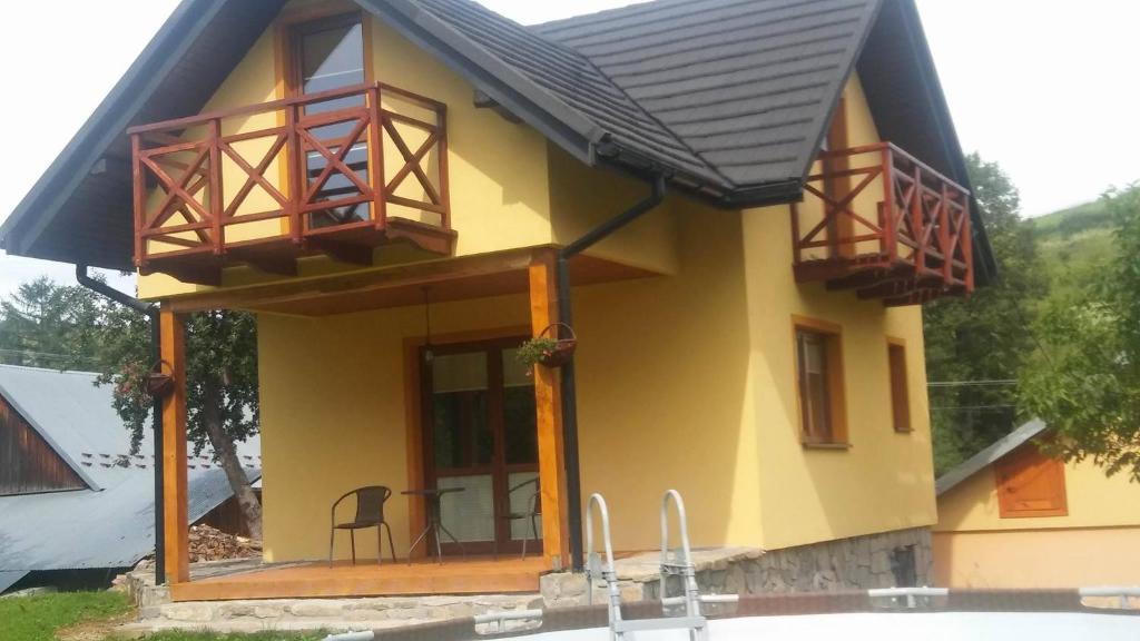 mały żółty dom z dwoma balkonami w obiekcie Domek u Basi w mieście Grywałd
