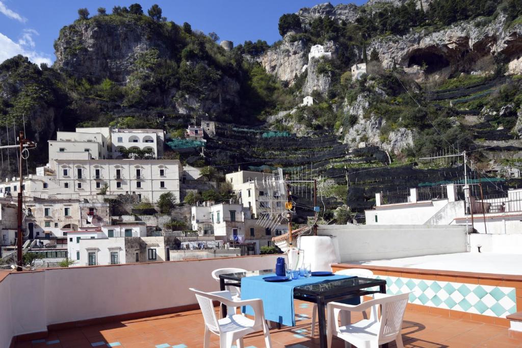 een blauwe tafel en stoelen op een balkon met een berg bij Pompeo in Atrani