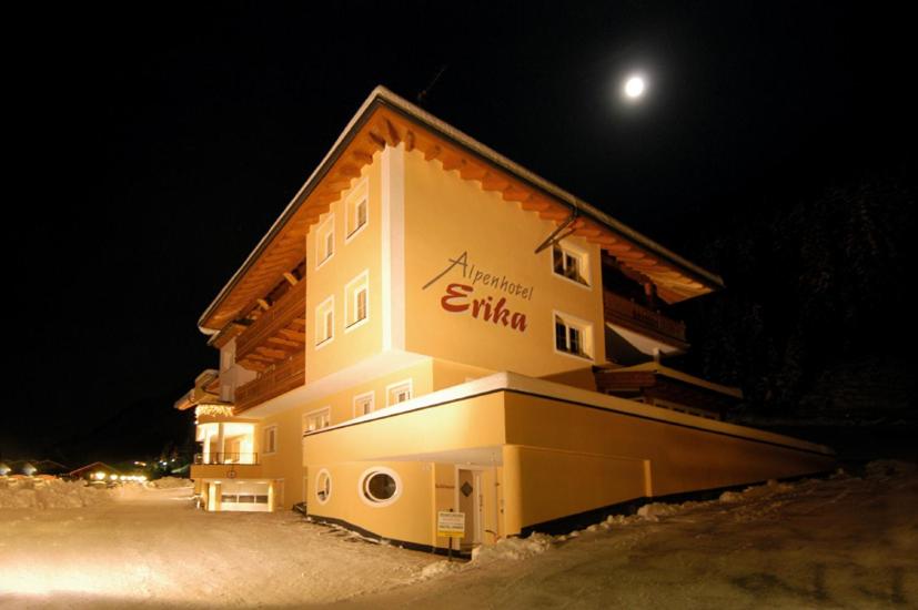 a building in the snow at night with the moon at Alpenhotel Erika in Ischgl