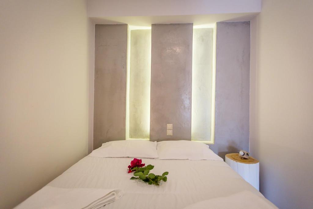 a bedroom with a bed with a red flower on it at Irene Studios in Agios Petros