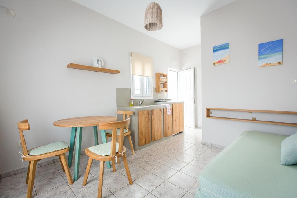 a kitchen with a table and chairs in a room at Irene Studios in Agios Petros