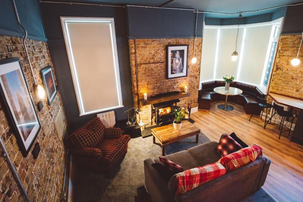 ein Wohnzimmer mit einem Sofa und einem Kamin in der Unterkunft Brooklyn lodge in Margate