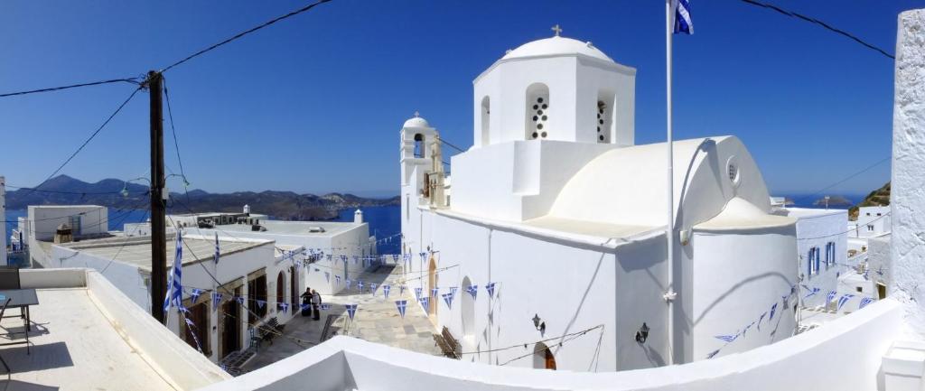 a white building with a clock tower on top at Studios Betty in Plaka Milou