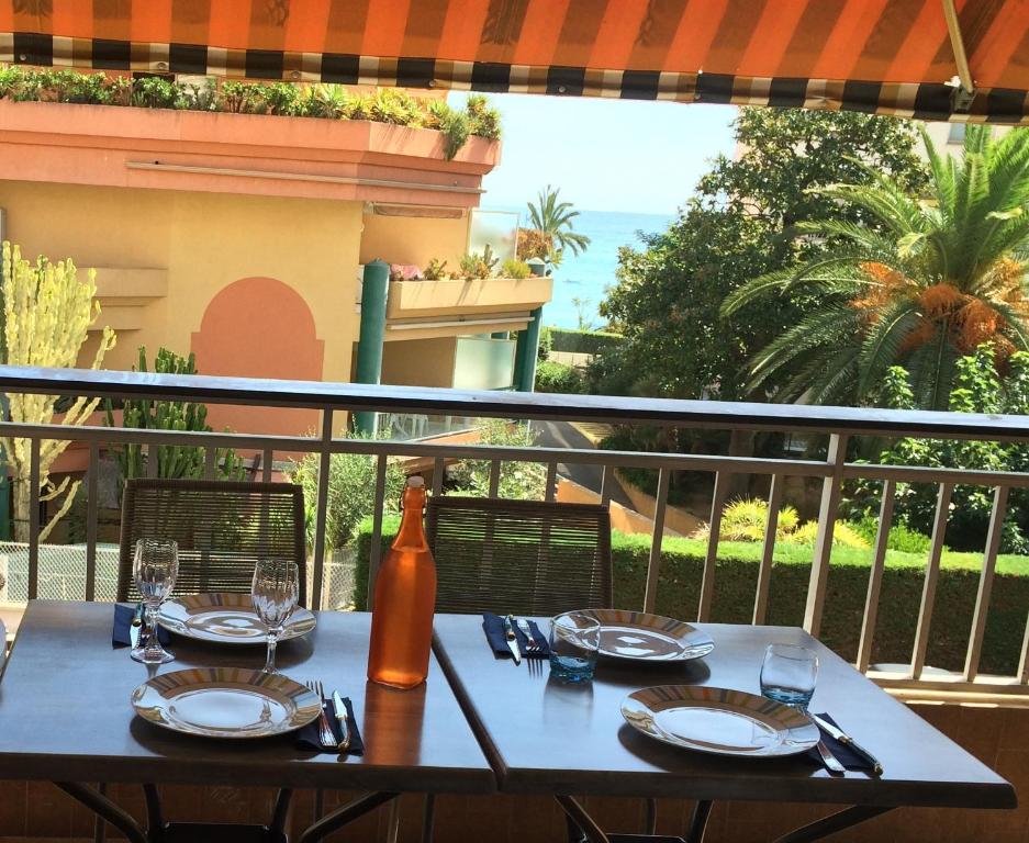 a table with plates and wine glasses on a balcony at LE JAD, ROQUEBRUNE in Roquebrune-Cap-Martin