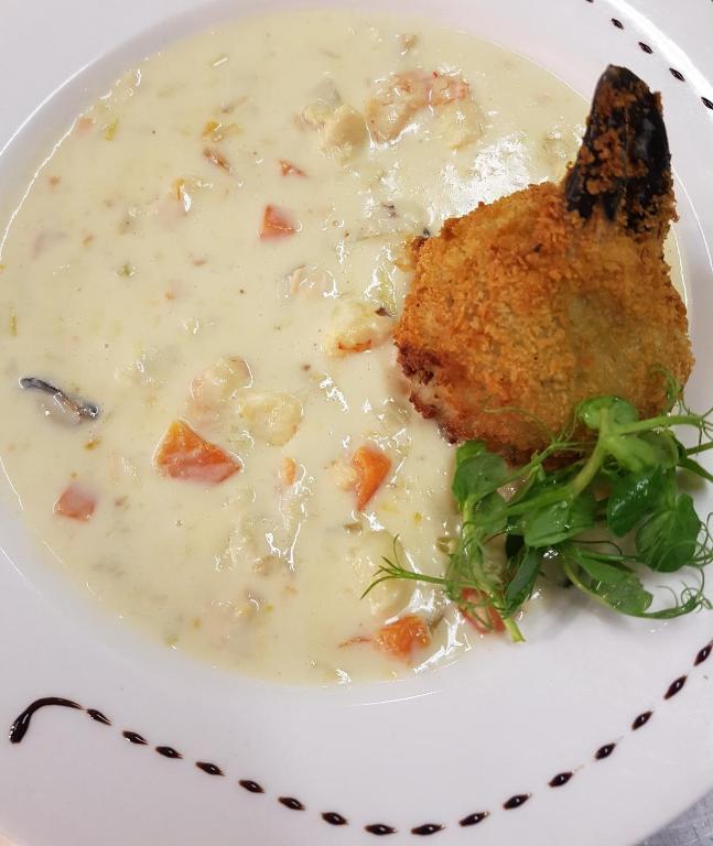 a plate of soup with a piece of chicken in it at Caisleain Oir Hotel in Annagry