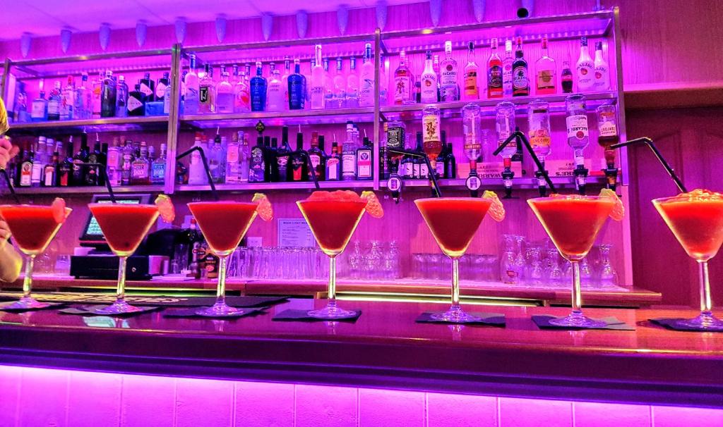 a bar with a bunch of martini glasses on the bar at Caisleain Oir Hotel in Annagry