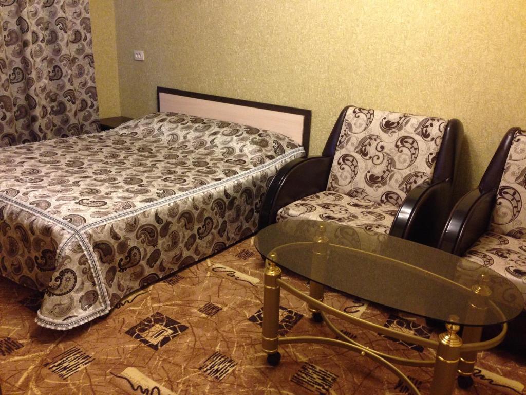 エカテリンブルクにあるАпартаменты Титова 23のベッドルーム1室(ベッド1台、テーブル、椅子付)
