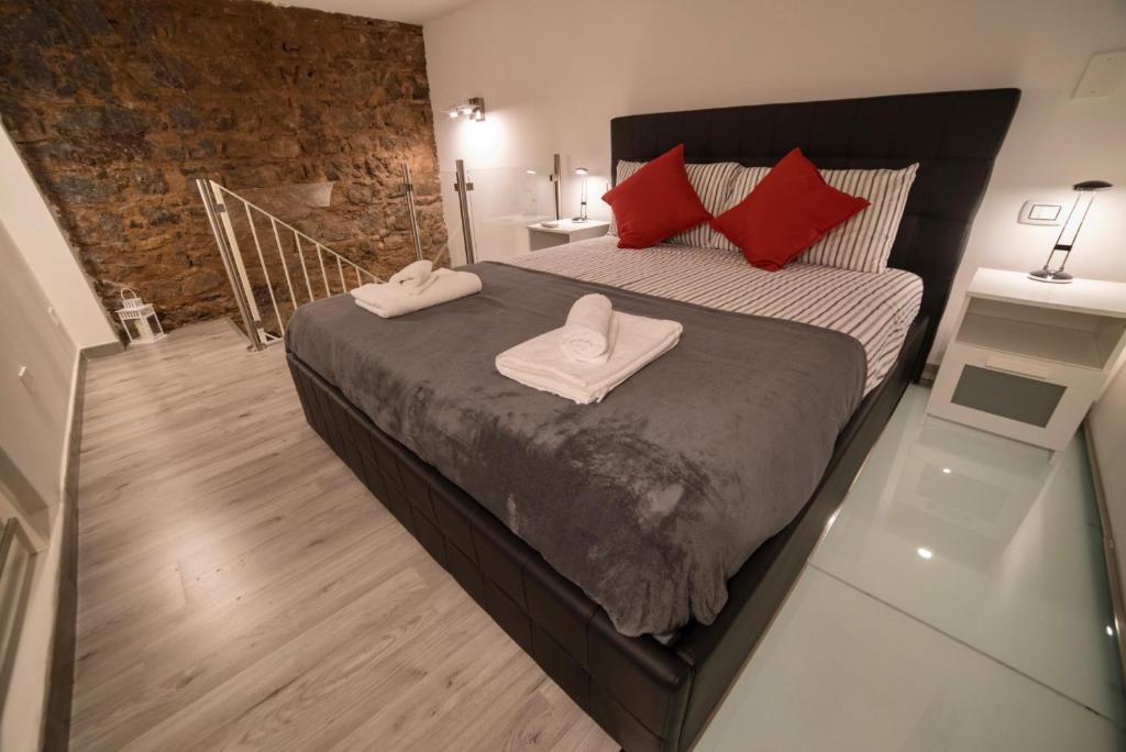 um quarto com uma cama grande e almofadas vermelhas em Loft Ramondetta 30tre em Catânia