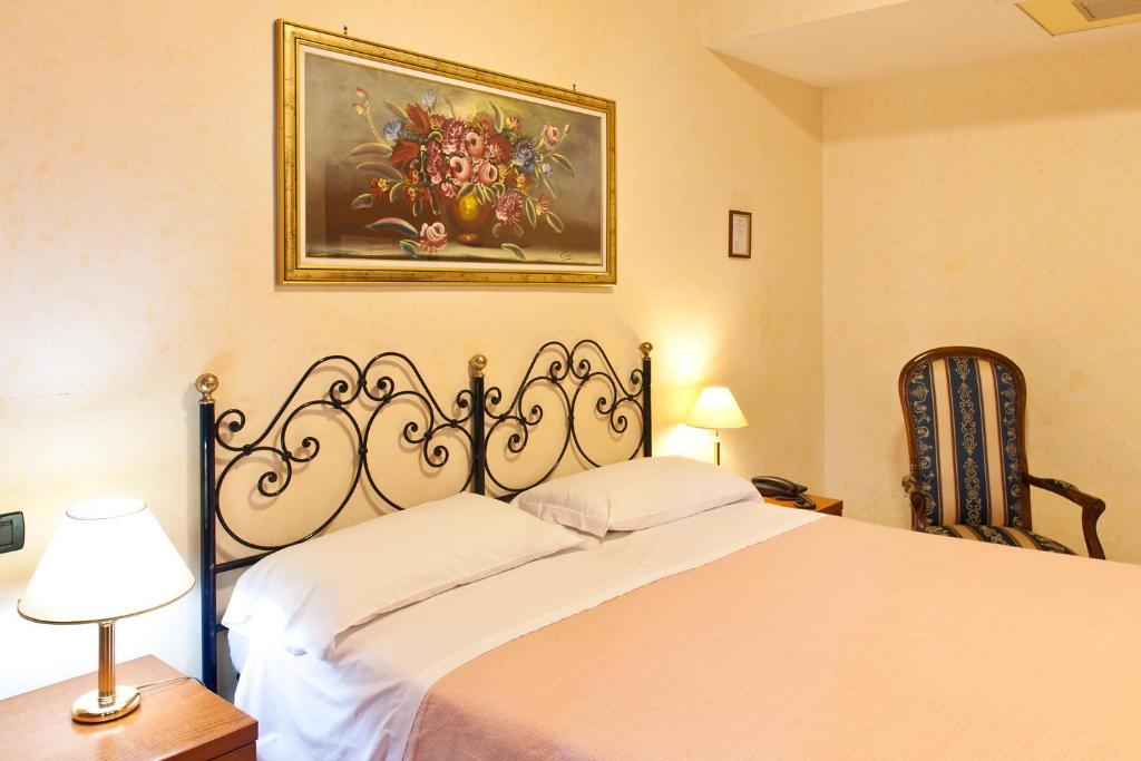 Un dormitorio con una cama y un cuadro en la pared. en Hotel Stromboli, en Roma