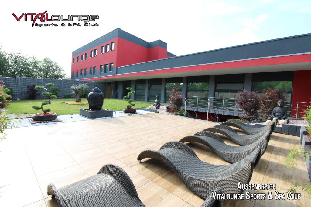 
people sitting on benches in front of a building at VitaLounge Sports & Spa Hotel in Gelsenkirchen
