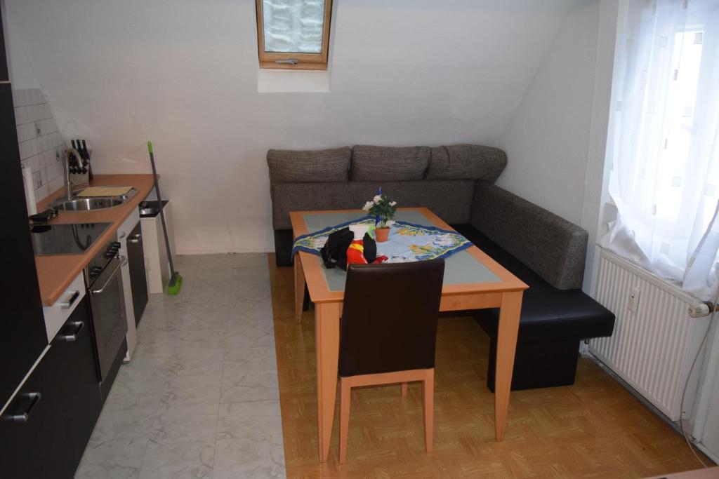 eine kleine Küche mit einem Tisch und einem Sofa in der Unterkunft Outlet Fewo Metzingen in Metzingen