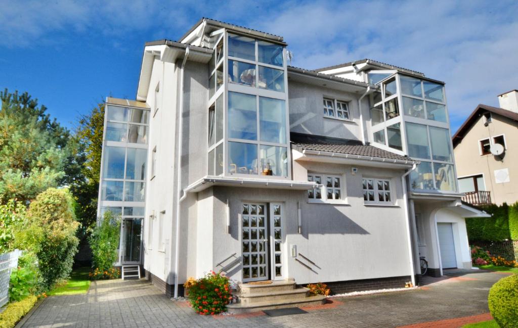 a large white house with glass windows at Appartementhaus Mila in Kolobrzeg in Kołobrzeg