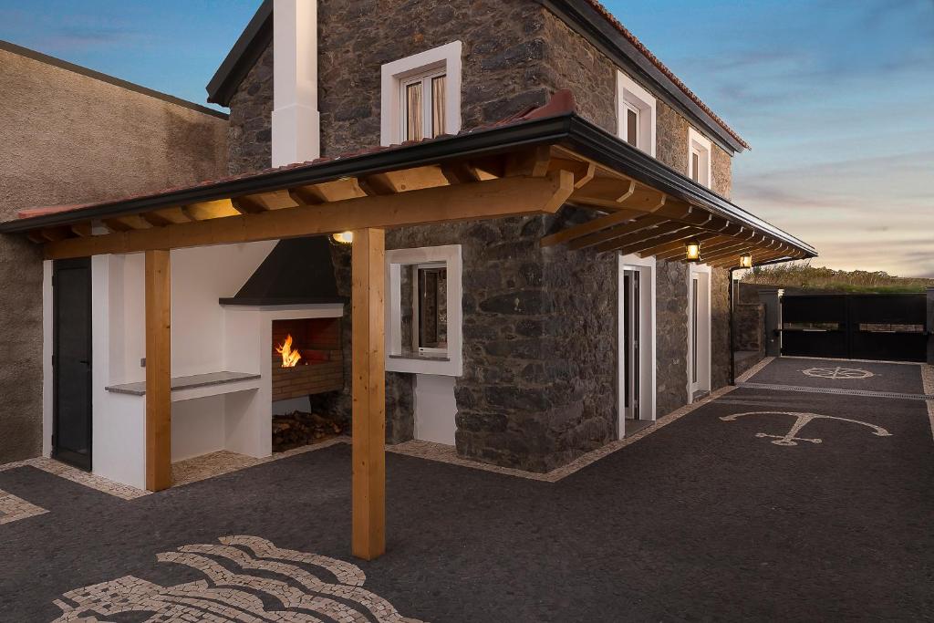 a wooden pergola on the side of a house at Casa do Leme in Arco da Calheta