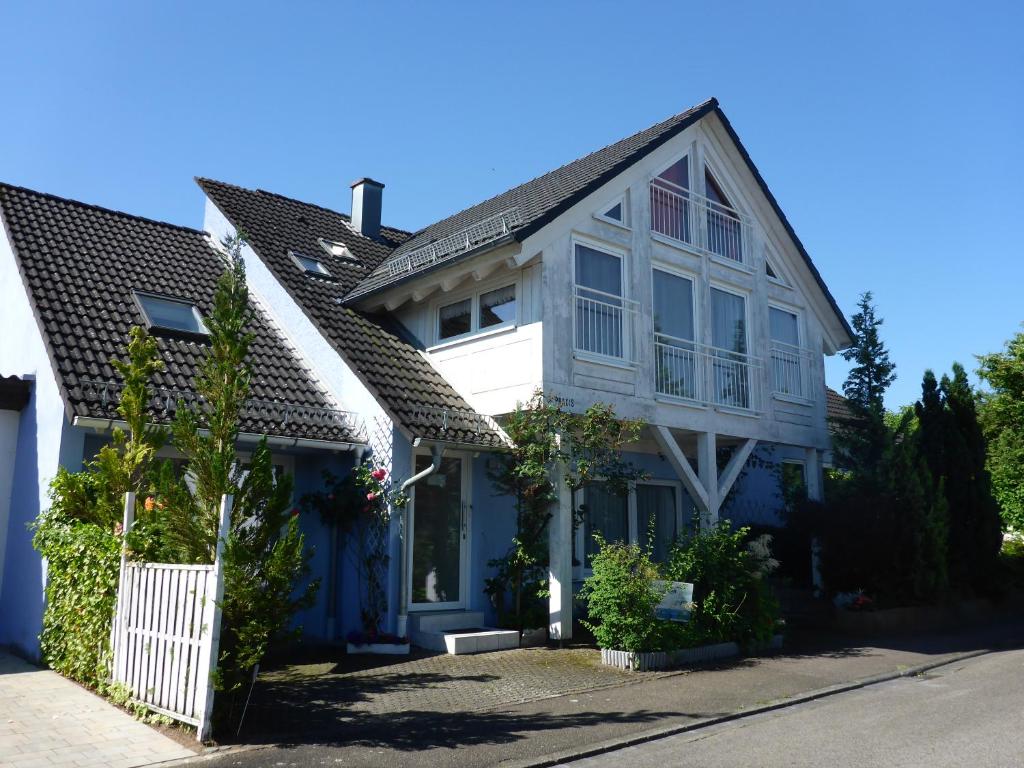 een blauw-wit huis met een wit hek bij Ferienwohnungen Lichtblick und Sonneck in Hilpoltstein