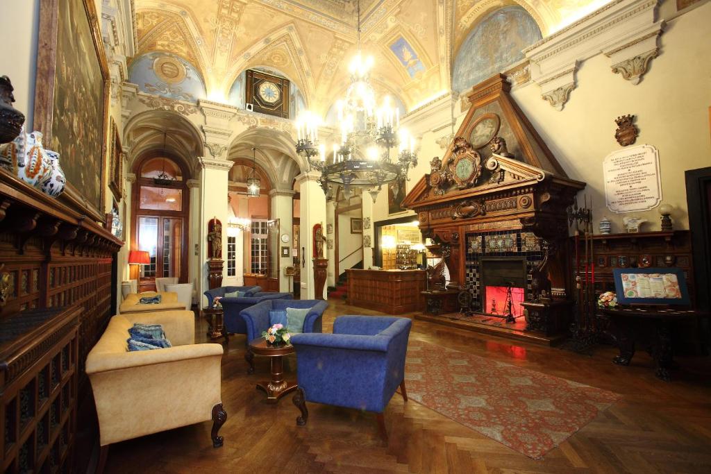 セストリ・レヴァンテにあるグランド ホテル ヴィラ バルビの青い椅子と暖炉付きの広い客室です。