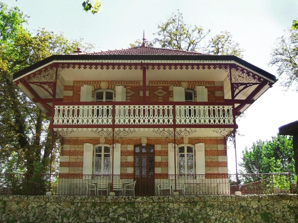 an old brick house with a balcony on top at Holiday Home Villa du Lac by Interhome in Beaune