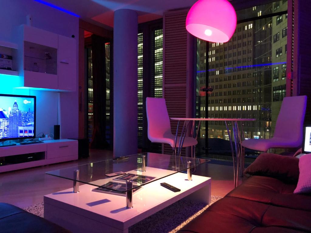 a living room with a couch and a table and a tv at Suite im Sony Center am Potsdamer Platz in Berlin