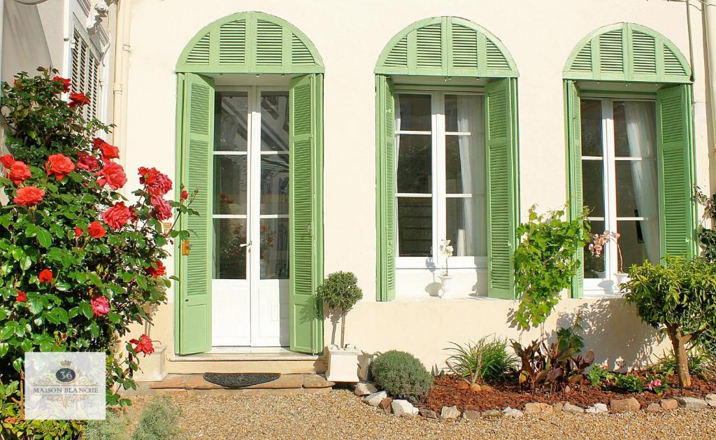 een huis met groene luiken en bloemen bij 'Maison Blanche' in Cannes